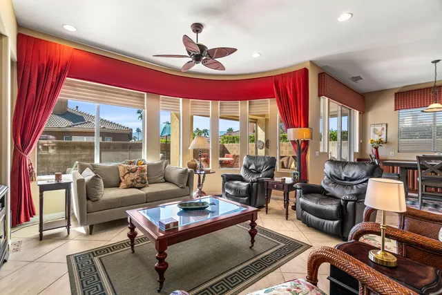 a living room with furniture a flat screen tv and a window