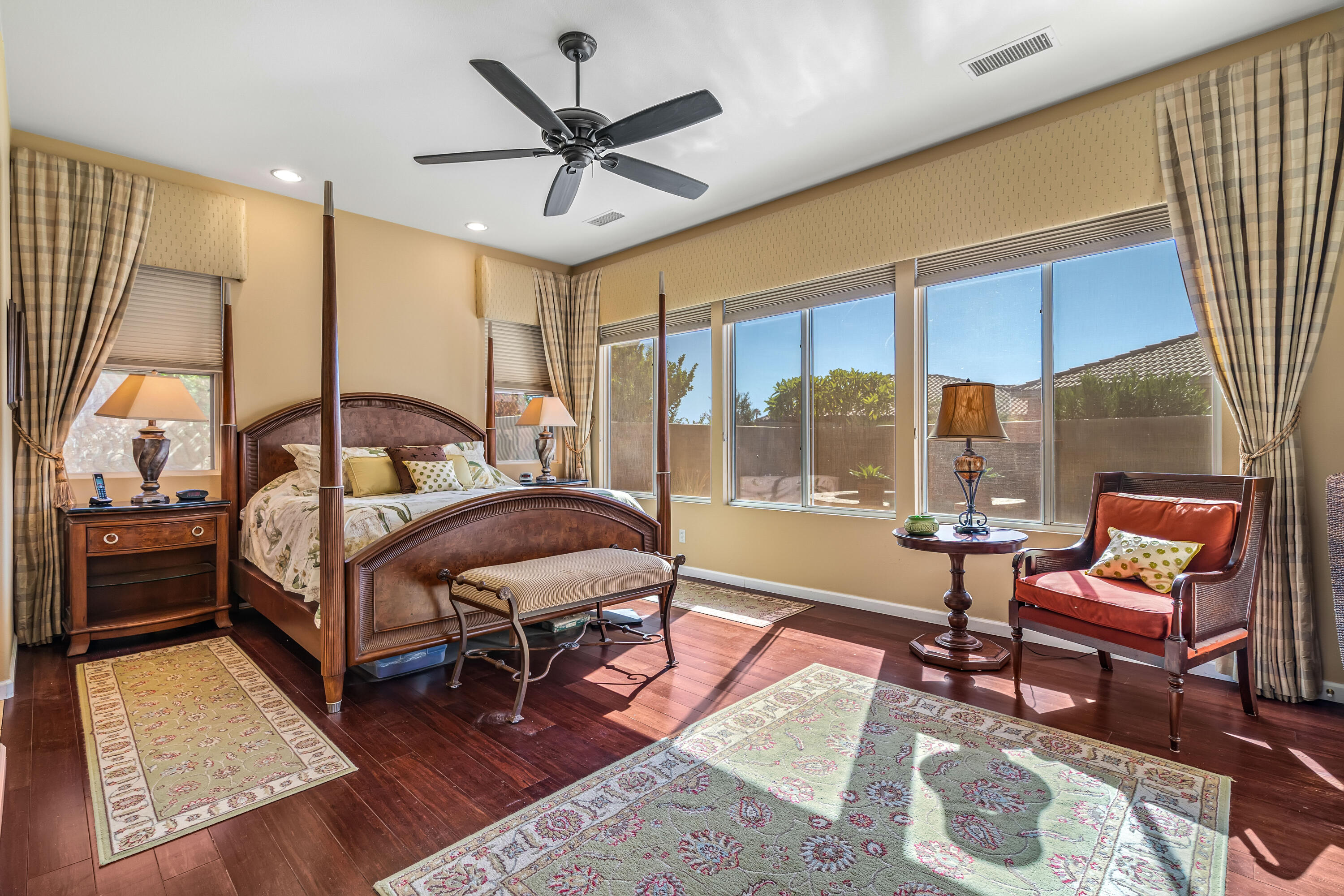 80607 Prestwick Place Indio, CA 92201 - Photo 26 of 68 a bedroom with a bed a lamp and a large window with wooden floor