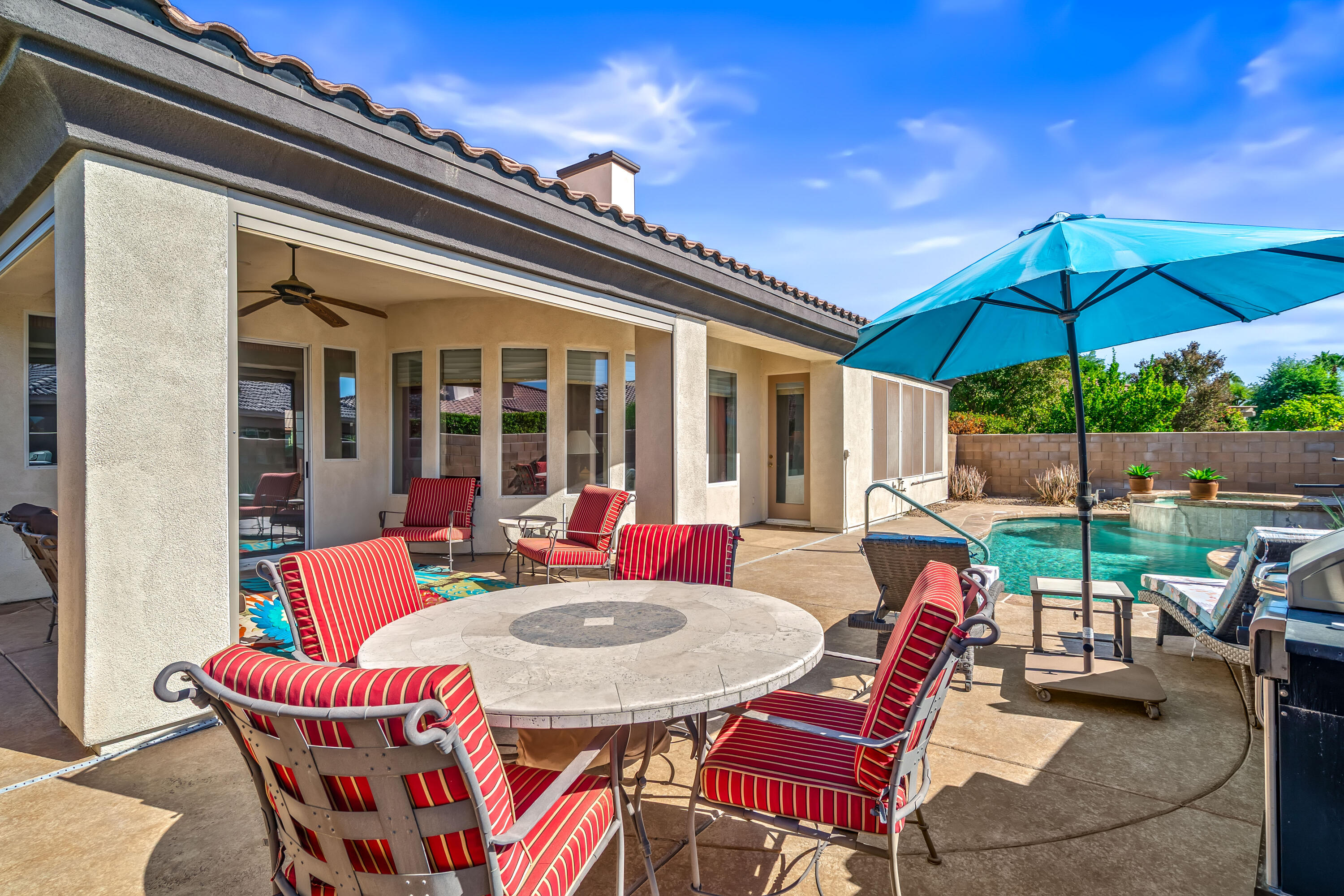80607 Prestwick Place Indio, CA 92201 - Photo 48 of 68 a view of a patio with a dining table and chairs under an umbrella