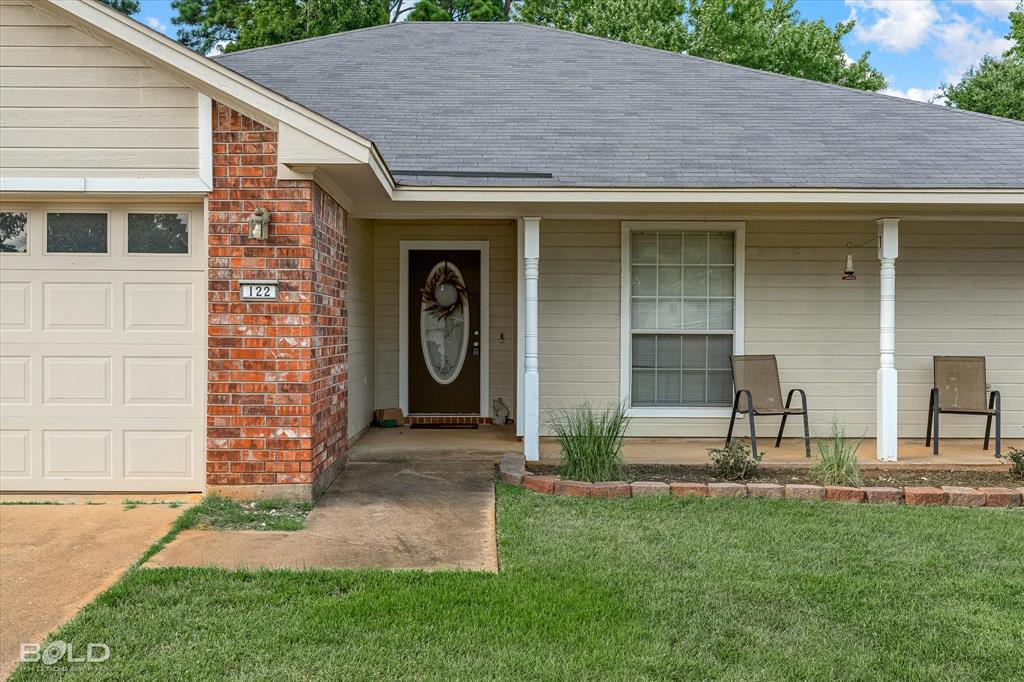 122 Ragan Lane Haughton, LA 71037 - Photo 30 of 34 Brick and siding exterior with a covered porch, an oval glass-paneled entry door, and a paneled garage door