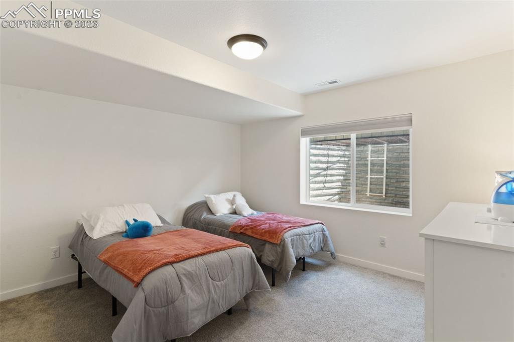 11969 Alydar Loop Colorado Springs, CO 80921 - Photo 27 of 39 a bedroom with two beds and a window
