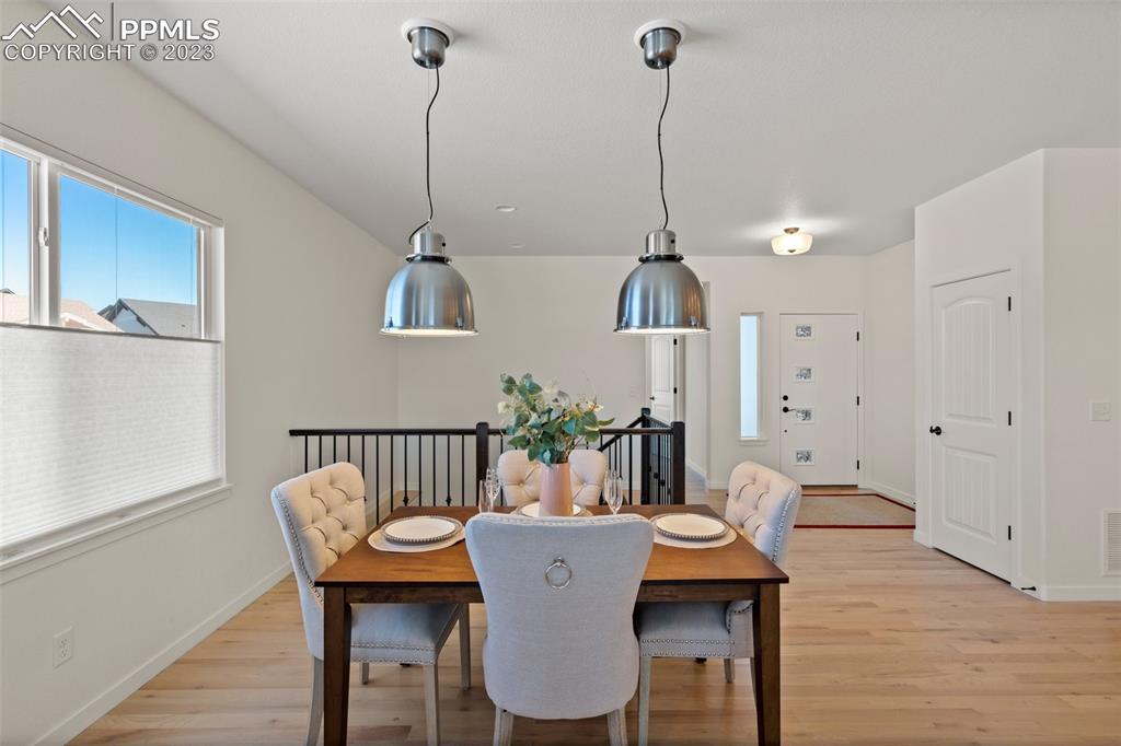 11969 Alydar Loop Colorado Springs, CO 80921 - Photo 8 of 39 a view of a dining room with furniture and wooden floor
