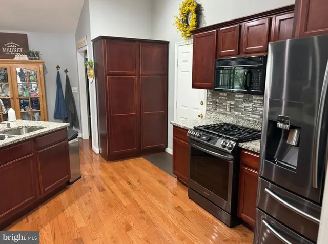 a kitchen with stainless steel appliances granite countertop a refrigerator stove and sink