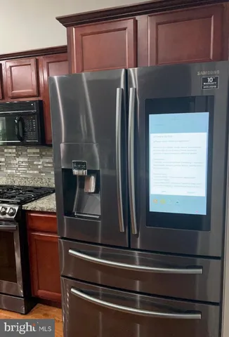 a metallic refrigerator freezer sitting in a kitchen