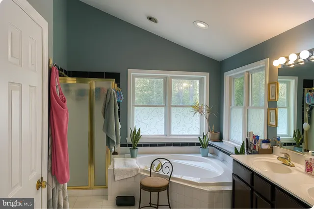 a bathroom with a granite countertop tub and a large window