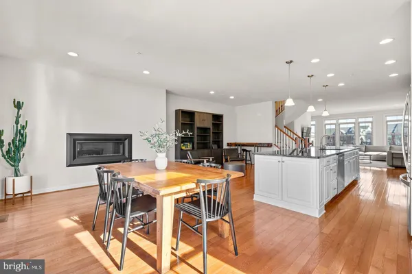 a kitchen with stainless steel appliances kitchen island granite countertop a wooden table and chairs