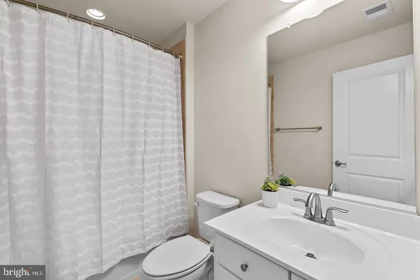 a bathroom with a sink a toilet and shower curtain