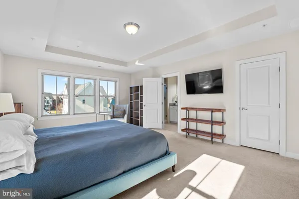 a spacious bedroom with a bed a window and television