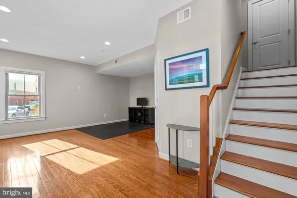 a view of a livingroom with wooden floor and stairs