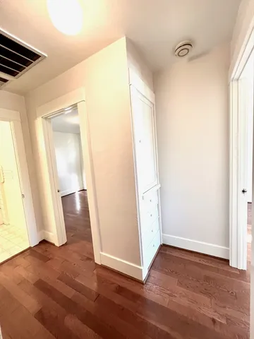 an empty room with wooden floor and window