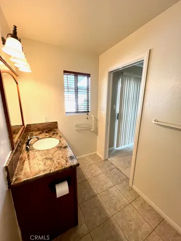 a bathroom with a granite countertop sink a toilet a mirror and bathtub