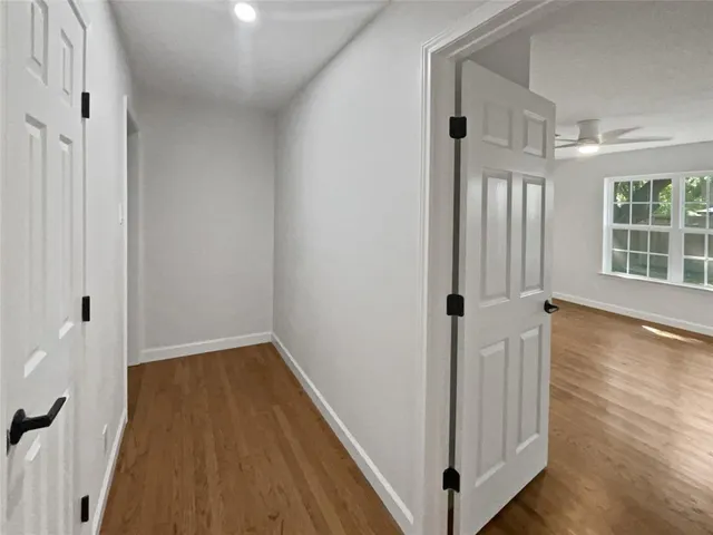 a view of a hallway with wooden floor and stairs