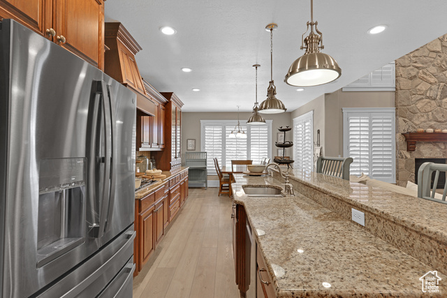 165 East 1550th South Perry, UT 84302 - Photo 16 of 26 Kitchen featuring light stone countertops, appliances with stainless steel finishes, sink, hanging light fixtures, and light hardwood / wood-style flooring