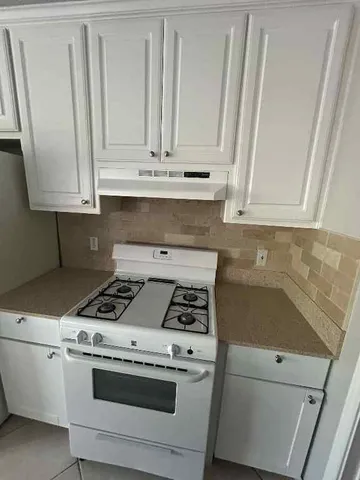 a kitchen with white cabinets and white appliances