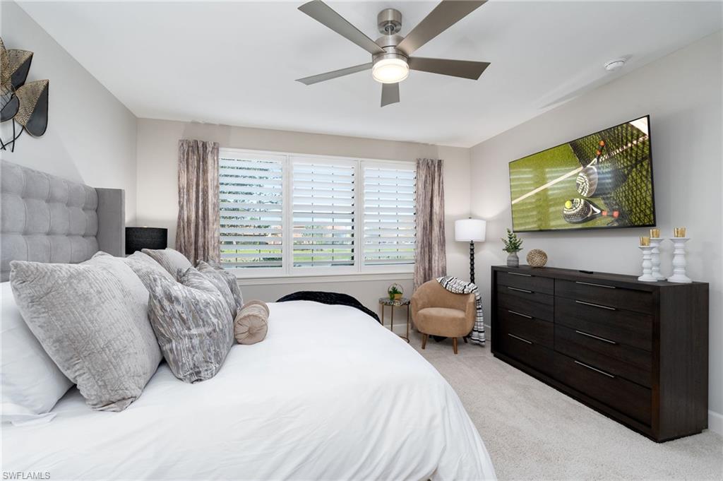 9650 Montelanico Loop, Unit 102 Naples, FL 34119 - Photo 14 of 36 a bedroom with a bed and a flat screen tv
