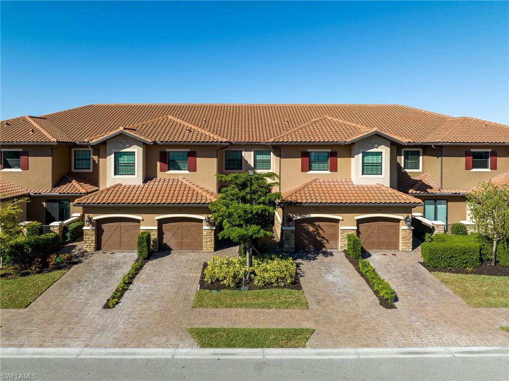 9650 Montelanico Loop, Unit 102 Naples, FL 34119 - Photo 2 of 36 front view of a house with a yard