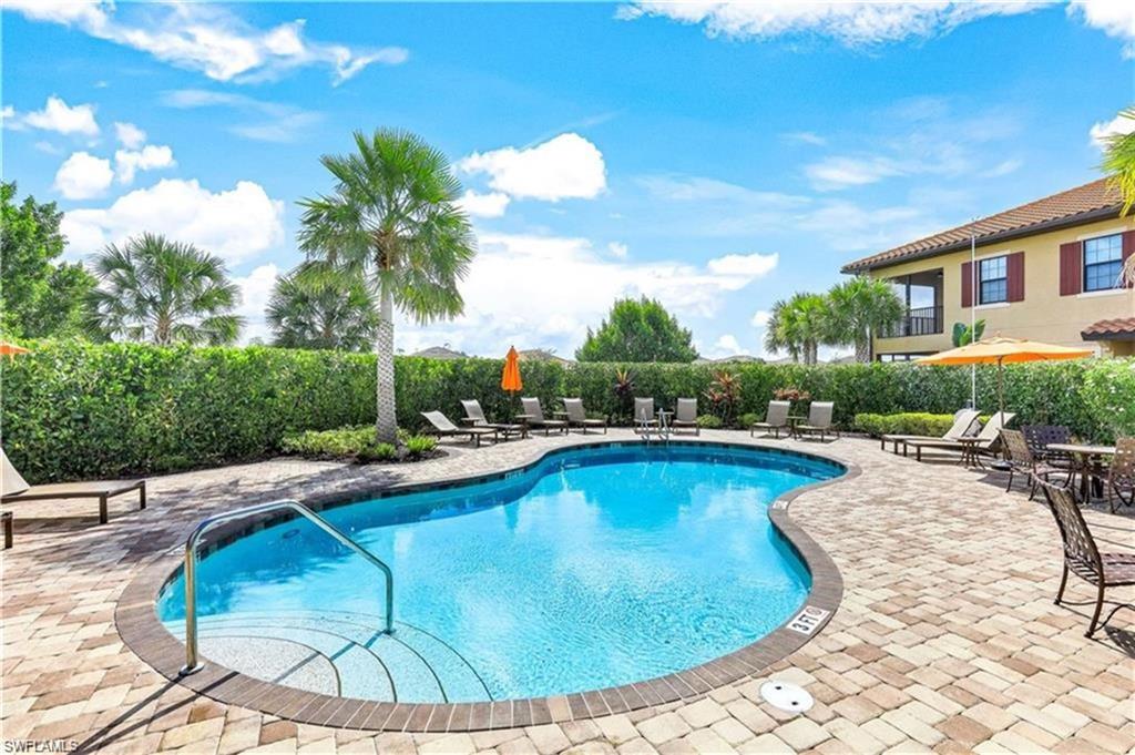 9650 Montelanico Loop, Unit 102 Naples, FL 34119 - Photo 25 of 36 a view of a swimming pool with lounge chair