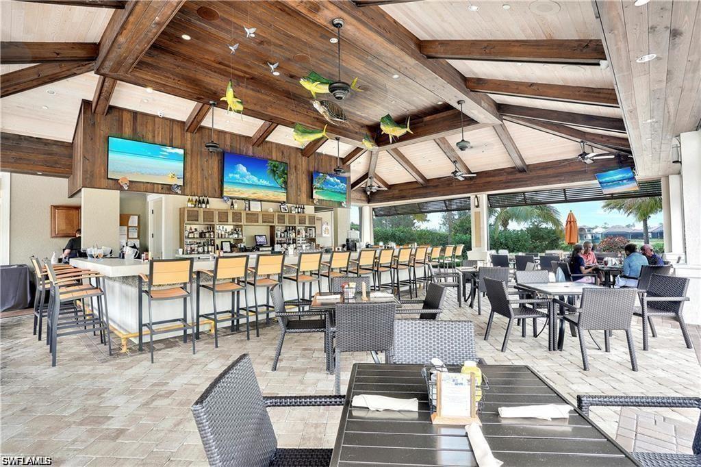 9650 Montelanico Loop, Unit 102 Naples, FL 34119 - Photo 26 of 36 a outdoor space with lots of tables a large window and chairs