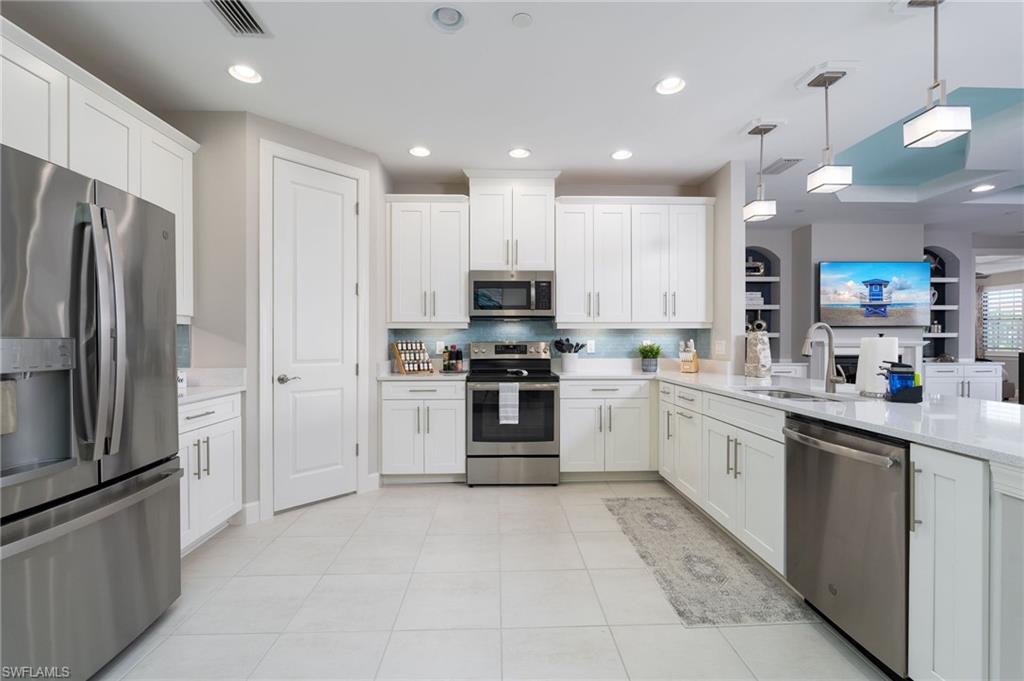 9650 Montelanico Loop, Unit 102 Naples, FL 34119 - Photo 3 of 36 a kitchen with stainless steel appliances granite countertop a refrigerator oven a sink and dishwasher
