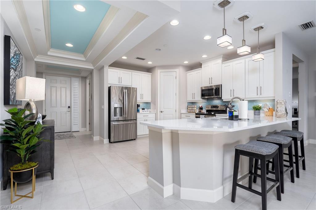 9650 Montelanico Loop, Unit 102 Naples, FL 34119 - Photo 5 of 36 a kitchen with stainless steel appliances a refrigerator sink and microwave