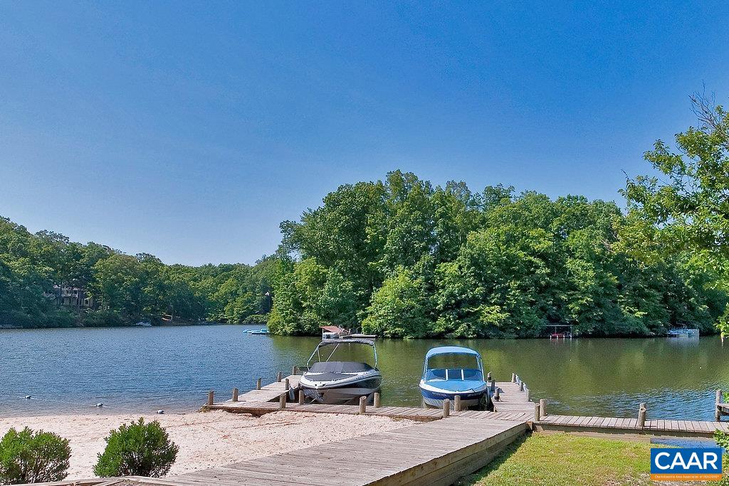 69 Laguna Road Palmyra, VA 22963 - Photo 7 of 15 a view of a lake with a yard and a wooden fence