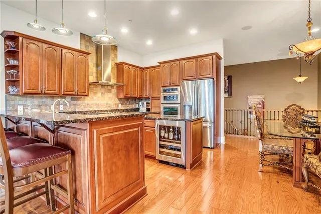 a kitchen with stainless steel appliances wooden floors and wooden cabinets