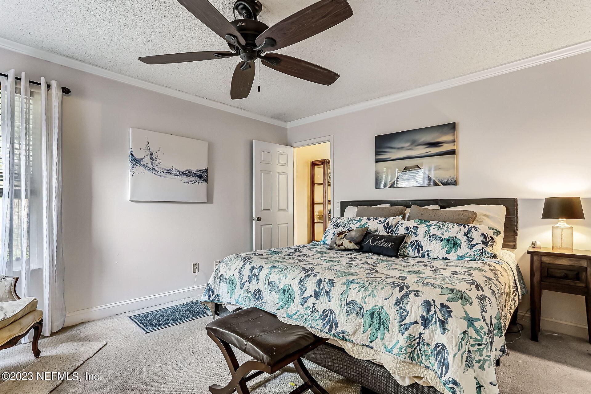 3866 Eunice Road Jacksonville, FL 32250 - Photo 14 of 41 a bedroom with a large bed and a chandelier