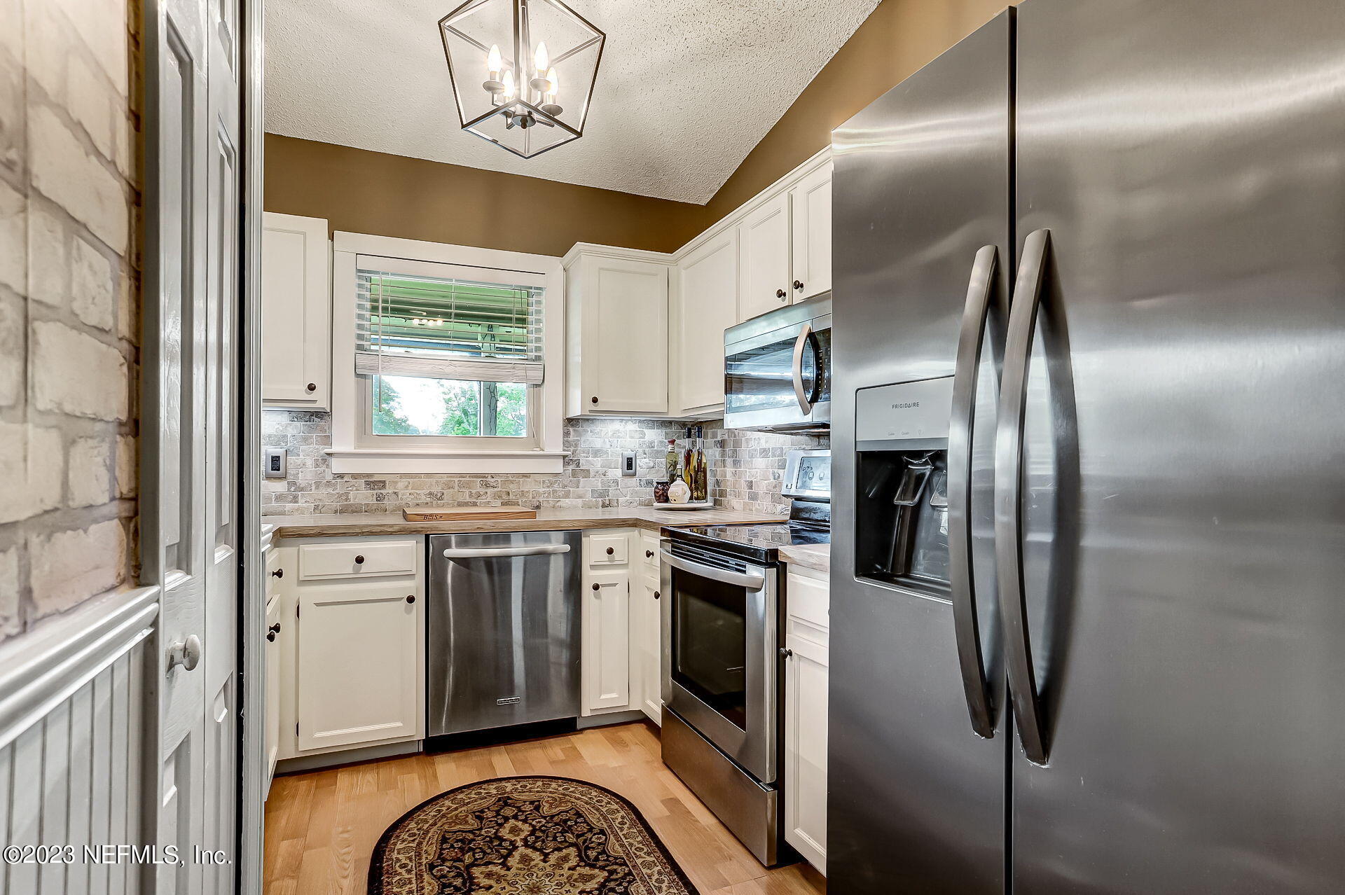 3866 Eunice Road Jacksonville, FL 32250 - Photo 7 of 41 a kitchen with stainless steel appliances granite countertop a sink a stove a refrigerator and island with wooden floor