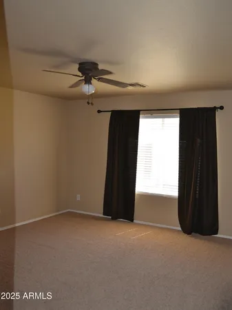 en empty room with windows and a ceiling fan