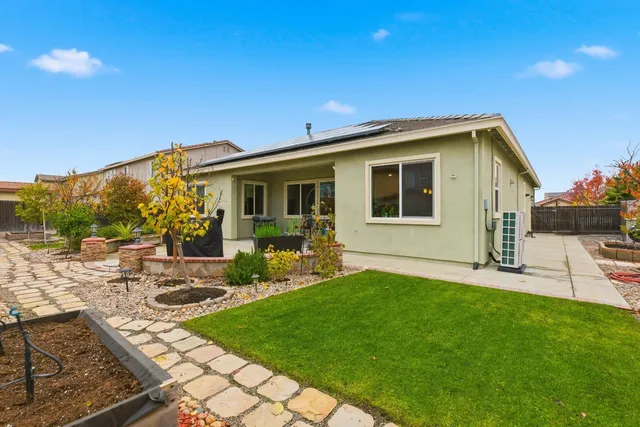 a view of a house with backyard sitting area and garden