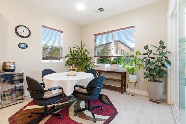 a dining room with furniture and a potted plant