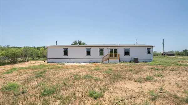 a view of a house with backyard and trees