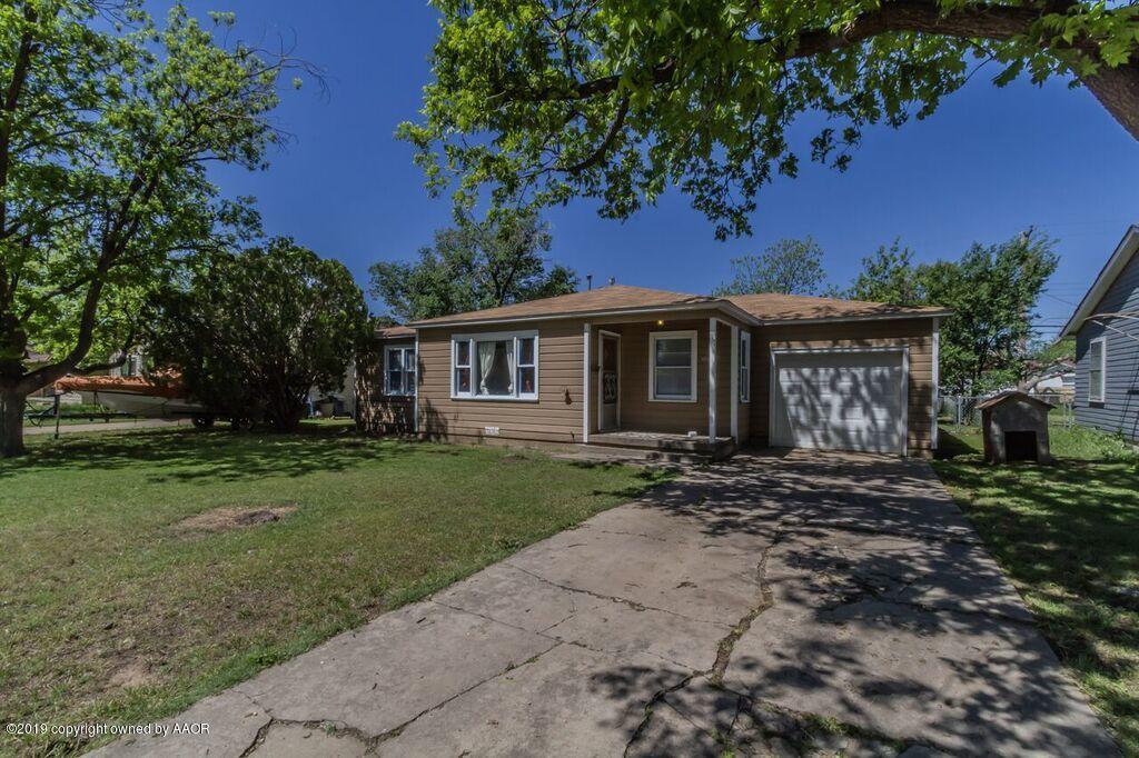 4308 South Travis Street Amarillo, TX 79110 - Photo 1 of 32 a front view of a house with a garden