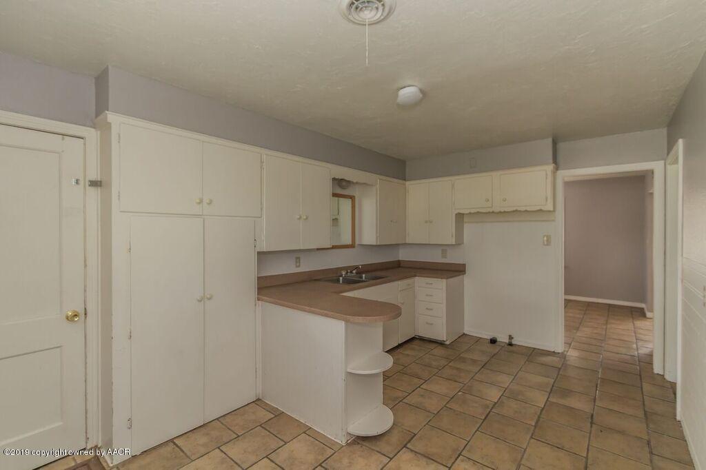 4308 South Travis Street Amarillo, TX 79110 - Photo 8 of 32 a kitchen with a stove a refrigerator and cabinets