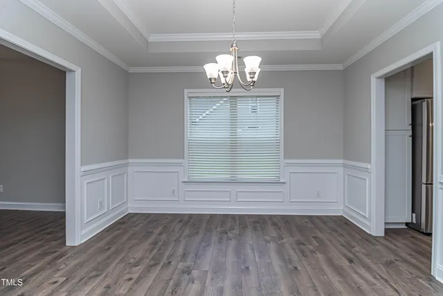a dining room with furniture a chandelier and wooden floor