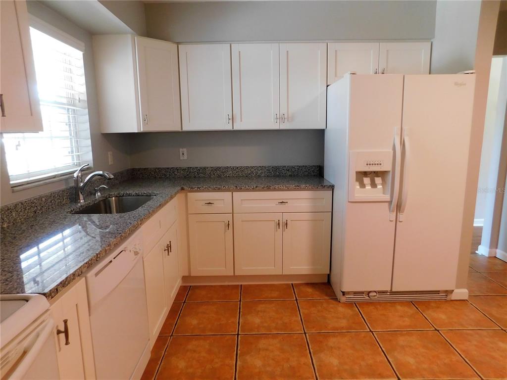 508 65th Avenue West Bradenton, FL 34207 - Photo 15 of 33 a kitchen with granite countertop a refrigerator sink and cabinets