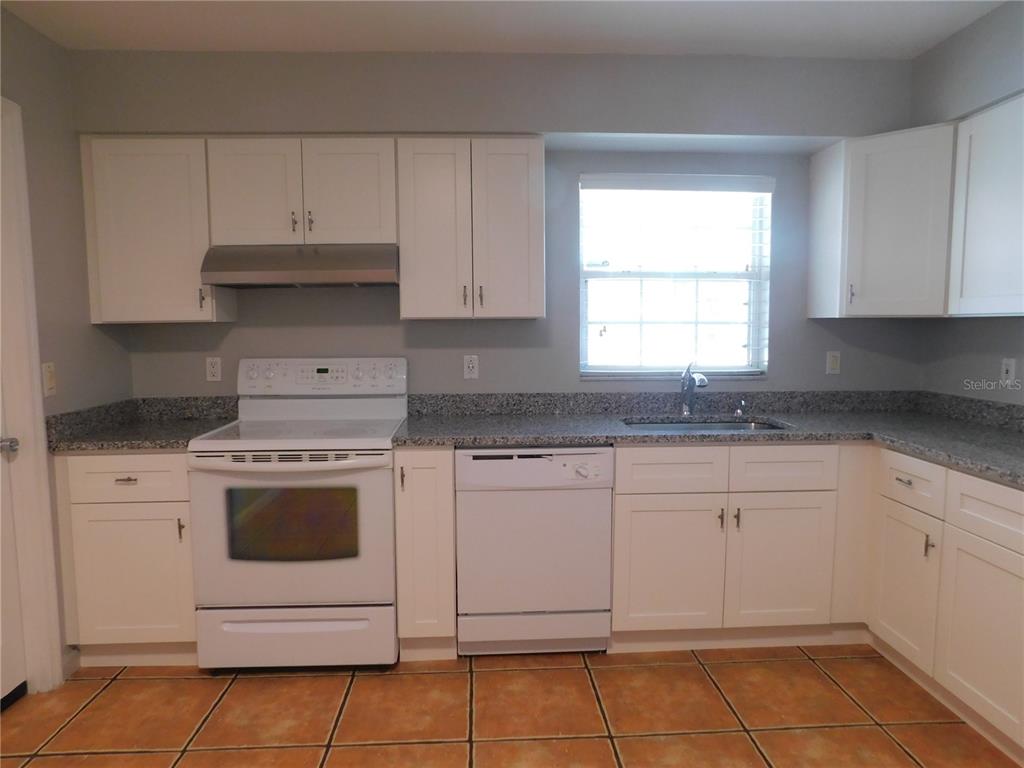 508 65th Avenue West Bradenton, FL 34207 - Photo 16 of 33 a kitchen with granite countertop white cabinets and white appliances