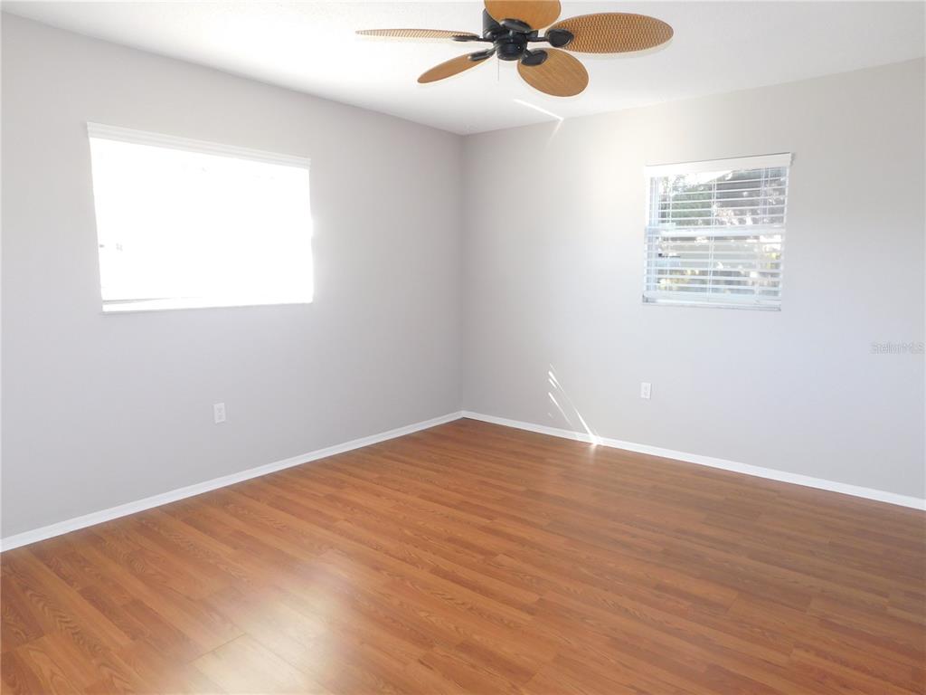508 65th Avenue West Bradenton, FL 34207 - Photo 7 of 33 an empty room with wooden floor fan and windows