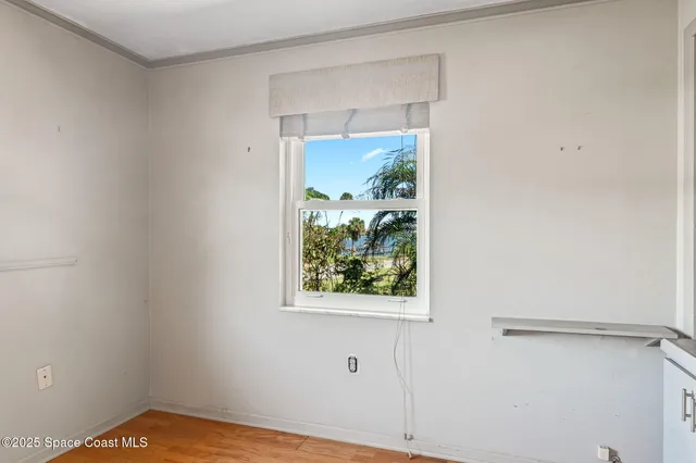 a view of a big room with wooden floor and windows