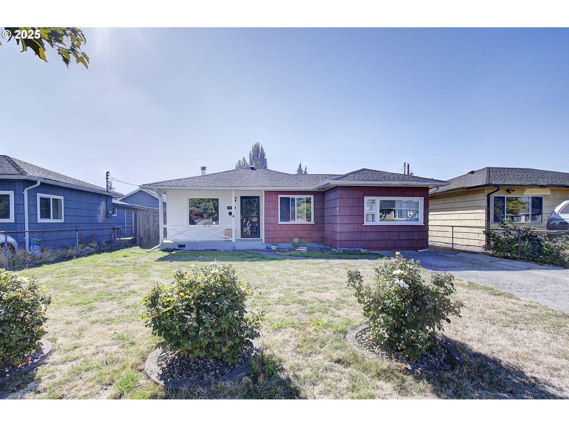 a view of a yard in front of a house with large windows