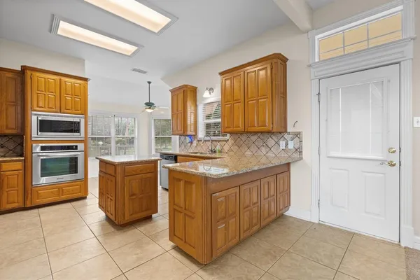 a kitchen with stainless steel appliances granite countertop a stove a sink and a refrigerator