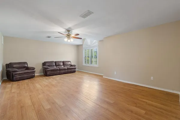 a living room with furniture and a ceiling fan