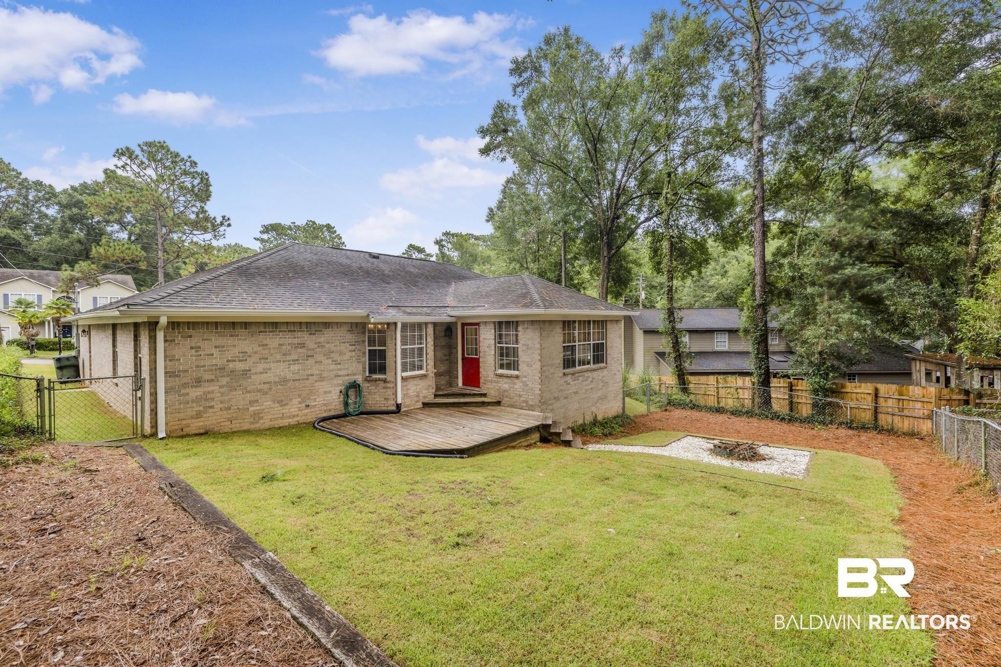 140 Hope Drive Daphne, AL 36526 - Photo 9 of 54 Rear view of house with a fenced backyard, brick siding, a wooden deck, a shingled roof, and a gate