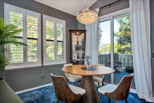 a view of a dining room with furniture a chandelier and wooden floor