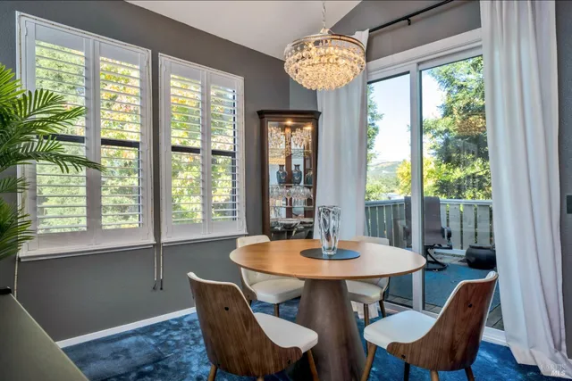 a view of a dining room with furniture a chandelier and wooden floor