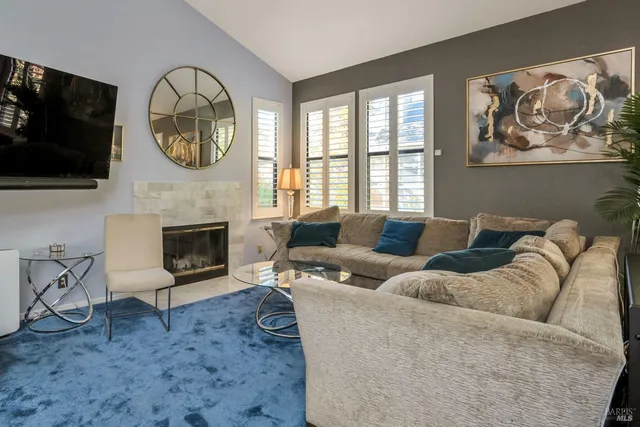 a living room with furniture a flat screen tv and a fireplace