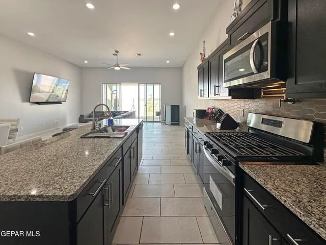 a bathroom with a granite countertop sink a toilet a mirror and shower