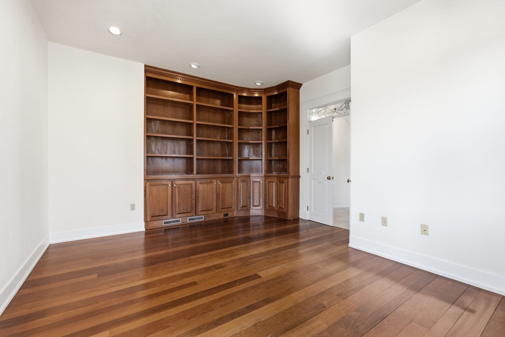 365 Middle Street Amherst, MA 01002 - Photo 12 of 42 an empty room with wooden floor and shelves