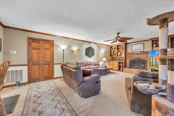 a living room with furniture a fireplace and a flat screen tv