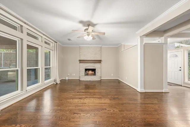 an empty room with wooden floor and fireplace